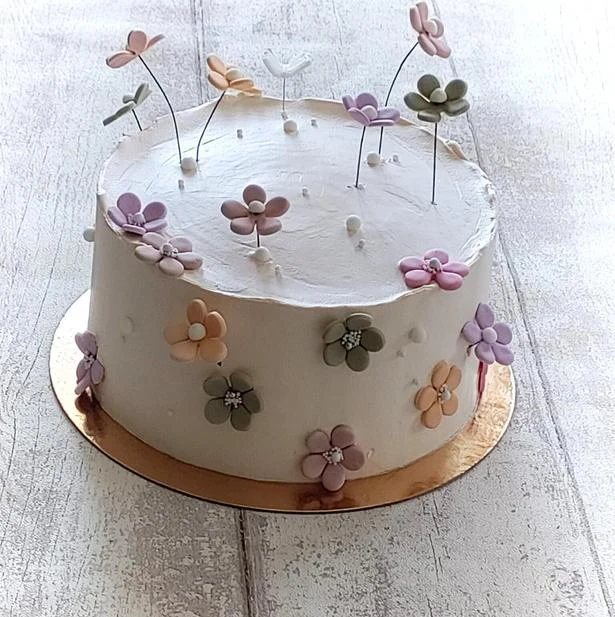 Tarta blanca con pequeñas flores en tonos suaves